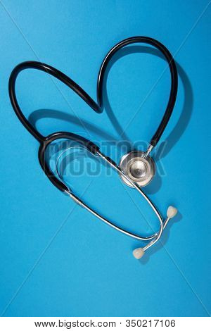black stethoscope on a blue background top view with copy space.