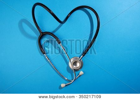black stethoscope on a blue background top view with copy space.
