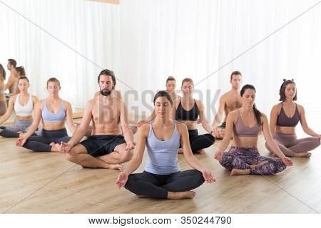 Group Of Young Sporty Attractive People In Yoga Studio, Practicing Yoga Lesson With Instructor, Sitt