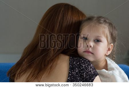 Portrait Of Little Girl Embracing Mother And Looking At Camera