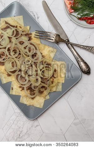 Beshbarmak Is A National Kyrgyz Dish - Square Pasta With Boiled Meat And Onions. On A Light Backgrou