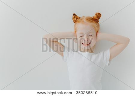 Positive Good Looking Ginger Freckled Beautiful Girl Covers Ears With Hands, Hears Very Loud Music, 