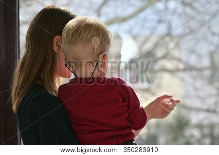 A Boy With Cochlear Implants With His Mother