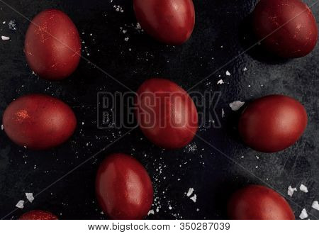Easter Eggs Painted In Red Monochrome Style Close Up On A Black Surface With Icing Crumbs. Eggs With
