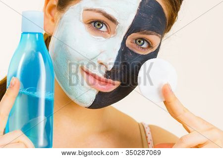 Woman With Clay Carbo Black Mask On One Half Face And White Mud On Second Half. Girl Removing Cosmet