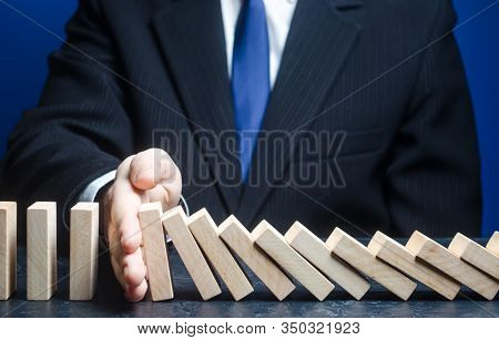 Businessman Stops Domino Falling. Strategy Development. Debt Restructuring. Risk Management Concept.