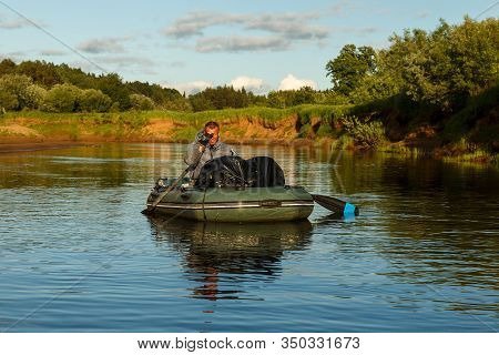 Tuzha, Russia - June 14, 2019: A Man Floats In A Rubber Boat On The Pizhma River. The Fisherman Is F