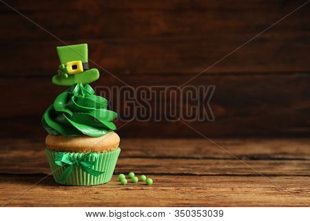 Delicious Decorated Cupcake On Wooden Table, Space For Text. St. Patrick's Day Celebration