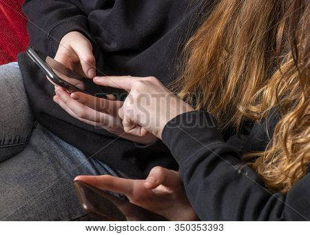 Teenagers On Their Mobile Phone Sharing Information With Each Other  Could Be Bullying Or Social Med
