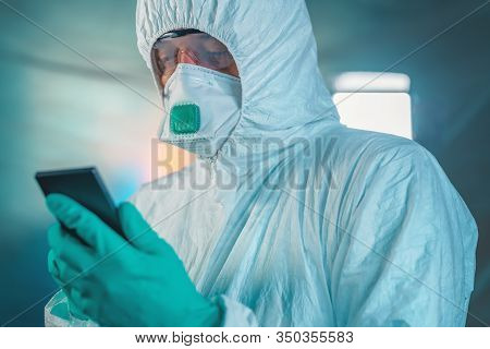 Epidemiologist Using Smartphone In Wuhan Coronavirus Quarantine, Conceptual Image With Selective Foc