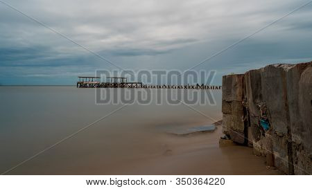 Closeup Of Sea Wall In Front Of Dilapidated Old Fishing Dock Collapsing Into The Sea In Pak Nam Pran