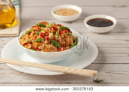 Tori Chahan Fried Japanese Rice With Vegetables And Chicken In Soy Sauce In A Black Plate On A Woode