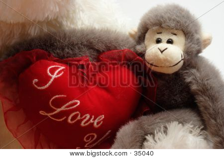 Stuffed Monkey Arms Around Bear Heart