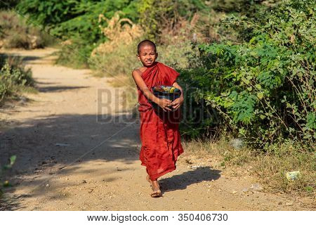 Bagan, Myanmar - Nov 16, 2019: Burmese Monk Beg For Alms In The Morning In Bagan, Myanmar Former Bur