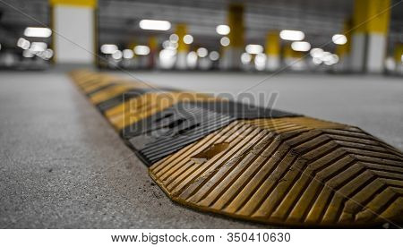 Traffic Safety Speed Bump On An Asphalt Road In A Parking Area. Speed Bumps (or Speed Breakers) Are