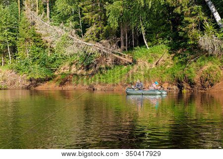 Tuzha, Russia - June 15, 2019: Fishermen Catch Fish On A Rubber Boat On A Forest River. Pizhma River