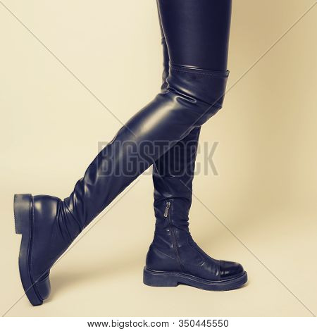Slim Women's Legs In Black Leather Pants And Stylish High Boots Stands Sideways