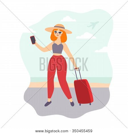 Young Girl A Blogger With Red Hair On Vacation Walks Along The Seashore With A Bag On Wheels