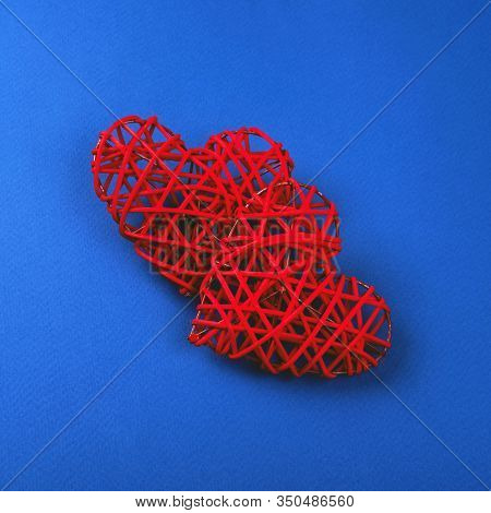 Two Beautiful Wicker Red Hearts On The Cornflowerblue Background. St Valentines Concept For Your Des