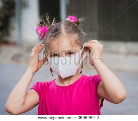 Girl wearing facial disposable mask to avoid viral infection. Virus protection