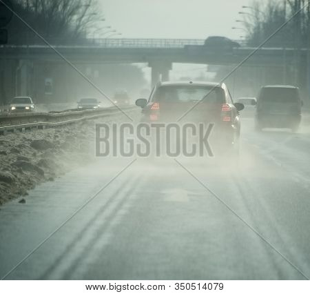 Water Mist Behind A Car On A Highway With Melding Snow
