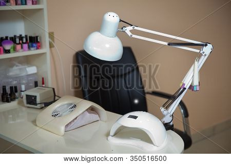 White Lamp On White Table With Nail Tool . Work Place Of Nail Amster With Manicure Tools, Uv-led Lam