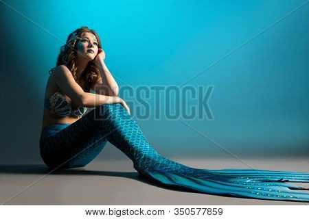 Woman In Mermaid Image Sitting On The Floor Shot