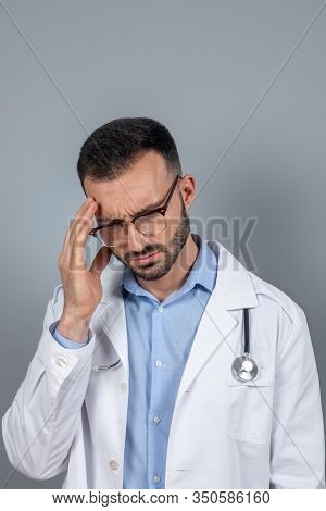 Doctor In Eyeglasses Suffering From A Headahce