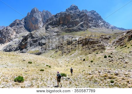 Turkey, Chamard - August 3, 2019: Tourists Walk Along The Road Through The Mountain Landscape In The