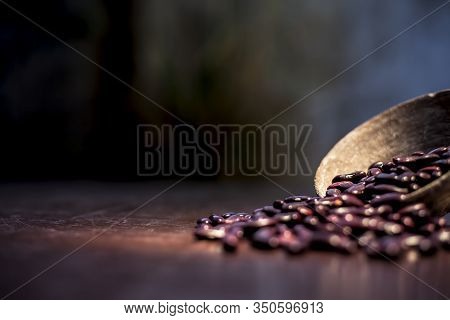 Close Up Of Raw Kidney Beans On Brown Colored Surface In A Clay Bowl With A Spotlight On It. Horizon