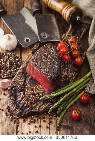 Slice Of Raw Beef Topside Joint With Salt And Pepper On Wooden Chopping Board With Meat Hatchet, Gar