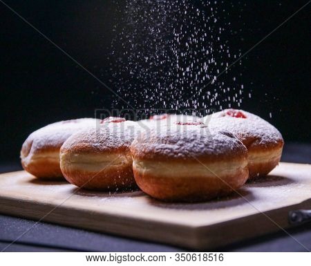 Hanukkah Food Doughnuts With Jelly And Sugar Powder On Black Background. Jewish Holiday Hanukkah Con