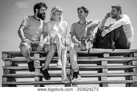 Group Of Friends Students Having Break And Chating Together Sitting At Clear Sky Background. Friends