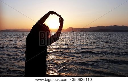 Koral Island / Thailand - January 22, 2020: Womans Hands Catching Sun At Sunset On The Sea Shore