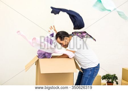 Man Looks Crazy, Unpacking Cardboard Boxes, Throwing Out His Belongings, Making Mess In New Apartmen