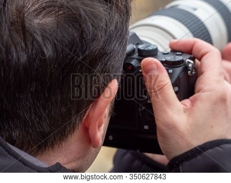 View From Behind Of A Man Taking A Photograph With A Reflex Camera And A Zoom Lens In Maderuelo In S