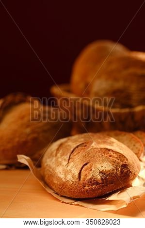 Different Buns Of Fresh Bread On A Brown Vintage Background. Freshly Baked Wheat Bread, Still Life W