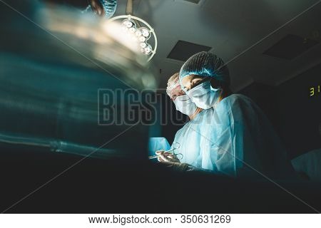 An International Professional Team Of Surgeon, Assistants And Anesthesiologist Perform A Complex Ope
