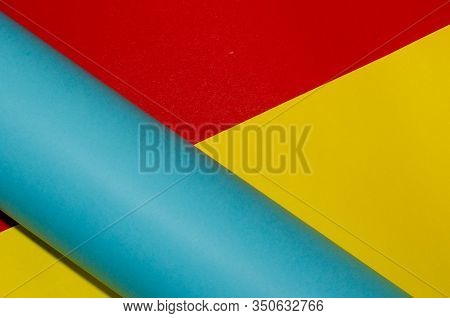 Colorful Background Of Blue Paper Roll And Red And Yellow Paper Sheets