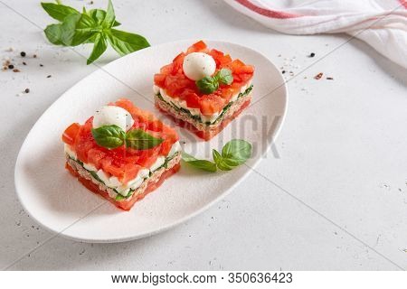 Portioned Tuna Salad With Tomatoes, Basil And Mozarella On White Plate On Light Background. Healthy 