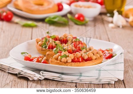 Friselle With Tomatoes And Chickpeas On White Dish.