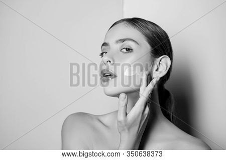 Portrait Of Beautiful Young Lady Touching Cheek With Hand Applying Face Cream. Selfcare Routine And 