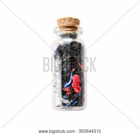 Small Old Vintage Glass Bottle With Cork With Floral Tea And Blue And Pink Petals Inside Isolated On