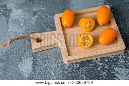 Fruit Kumquat Against A Grey Concrete Background
