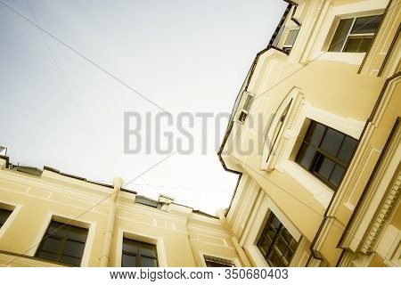 Saint-petersburg In Russia Courtyard With Orange Aged Walls Shot From Bottom To The Blue Sky. Houses