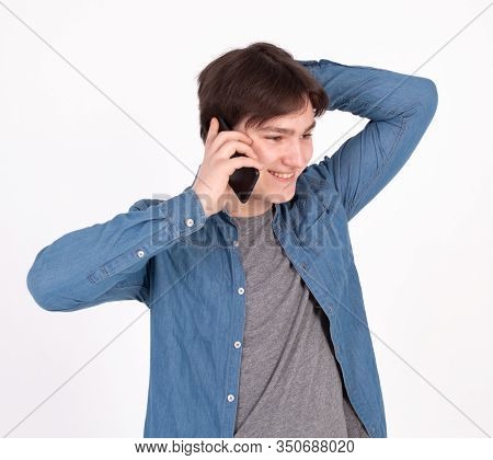 Young Smiling Man Talking On The Mobile Phone And Looking Away. Isolated On White.