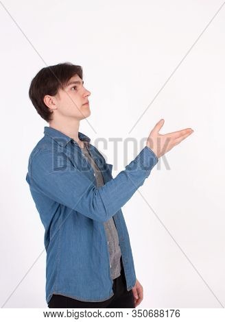 Young Man Nerd Pointing Finger Aside At Blank Copy Space, Isolated On White Grey Studio Background.
