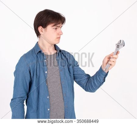Portrait Of Young Man While Holding Wrench On White Background.