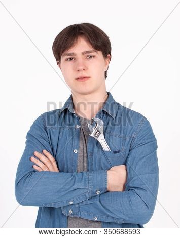 Young Male Teenager In Blue Shirt On Blue Background With Tools Screwdriver And Wrench.