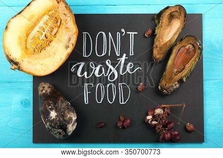 Close Up Of A Chalkboard With Dont Waste Food Lettering And Rotten Fruits. Selective Focus